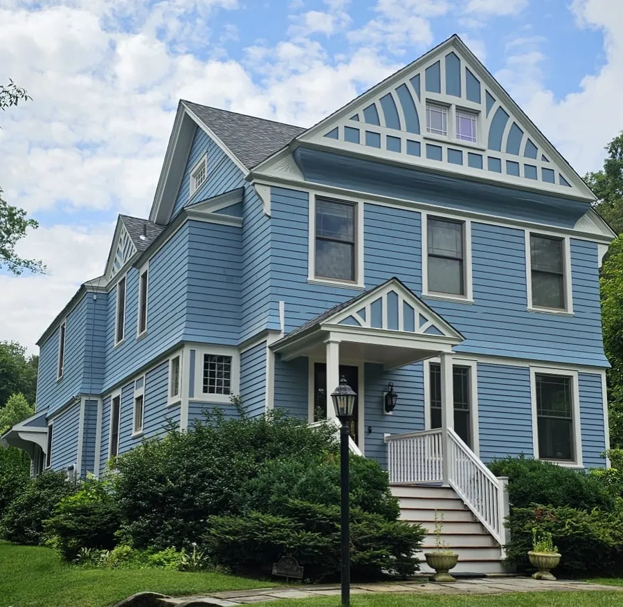 The same home after a full exterior repaint in blue with crisp white trim