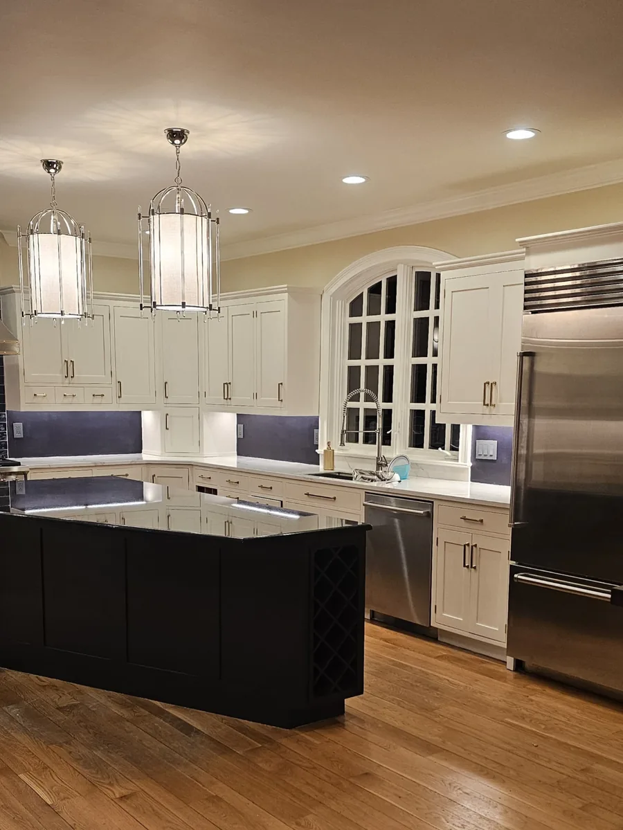 The finished kitchen with sprayed off-white cabinets and a black island